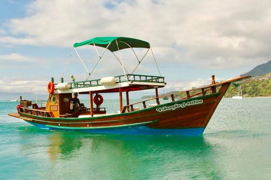 Perfil do barco artesanal Vibração Positiva sobre águas claras