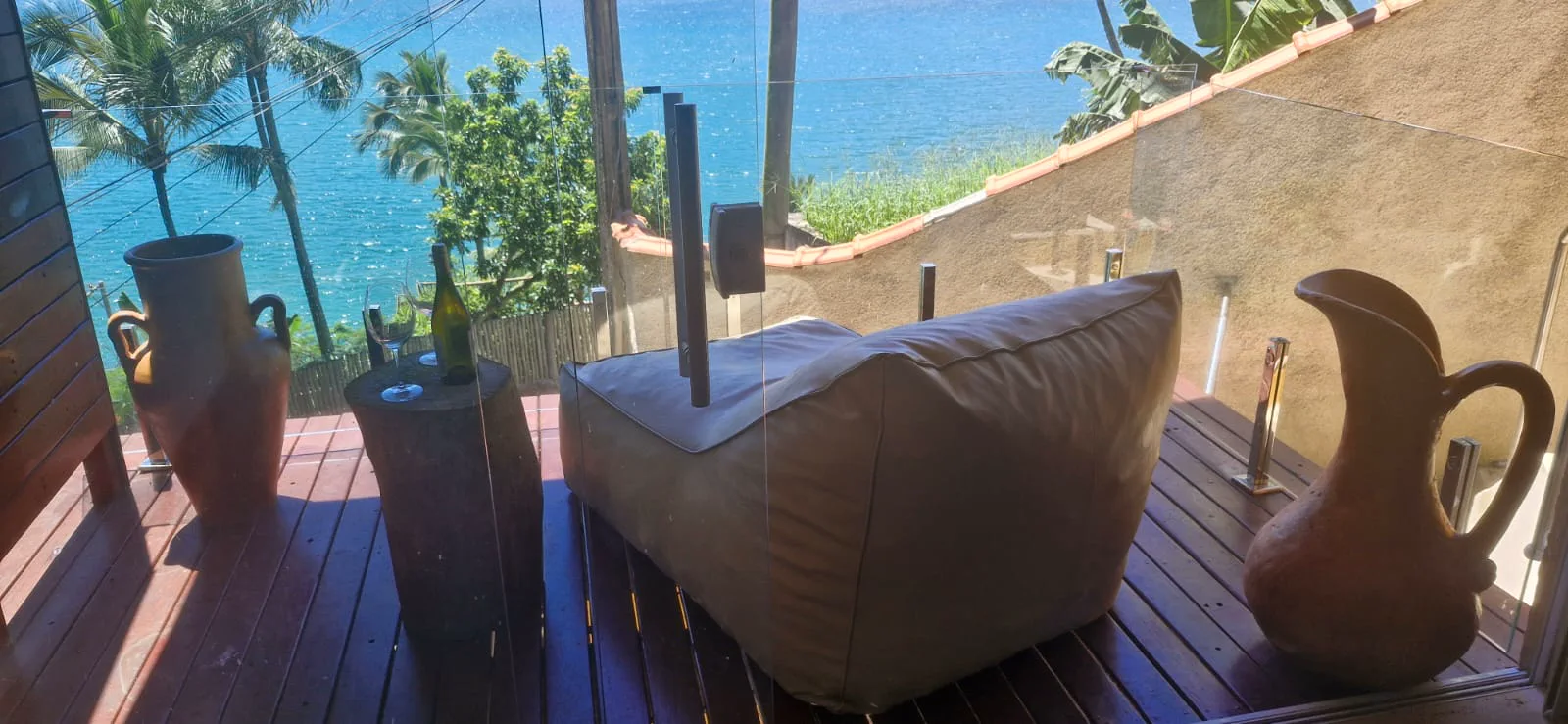 Varanda com poltrona e vista para o mar