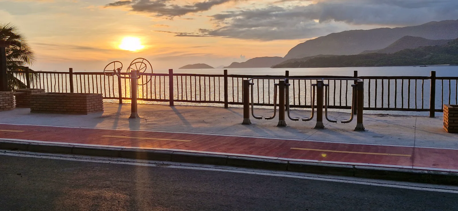 Academia ao ar livre na orla diante do mar e das montanhas ao pôr do sol