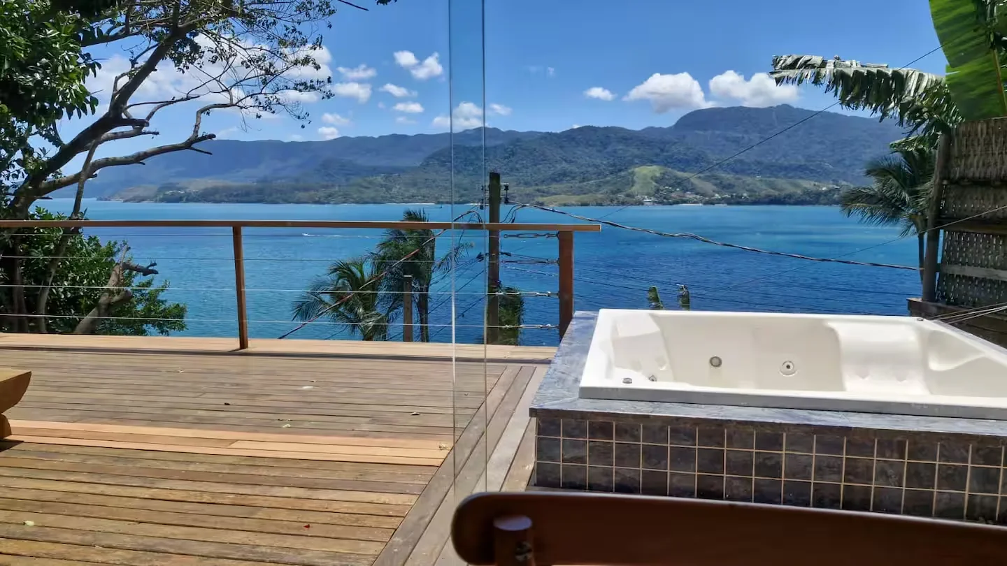 Hidromassagem no deck da Casa dos Tucanos com vista ampla para o mar
