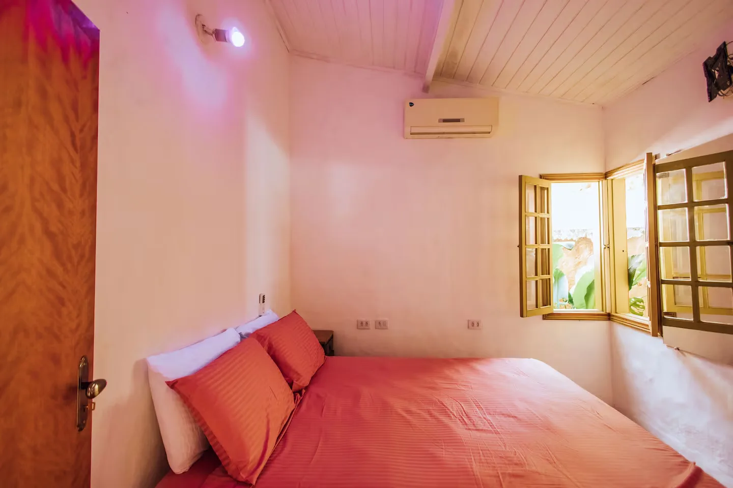 Suíte com cama de casal e janela aberta